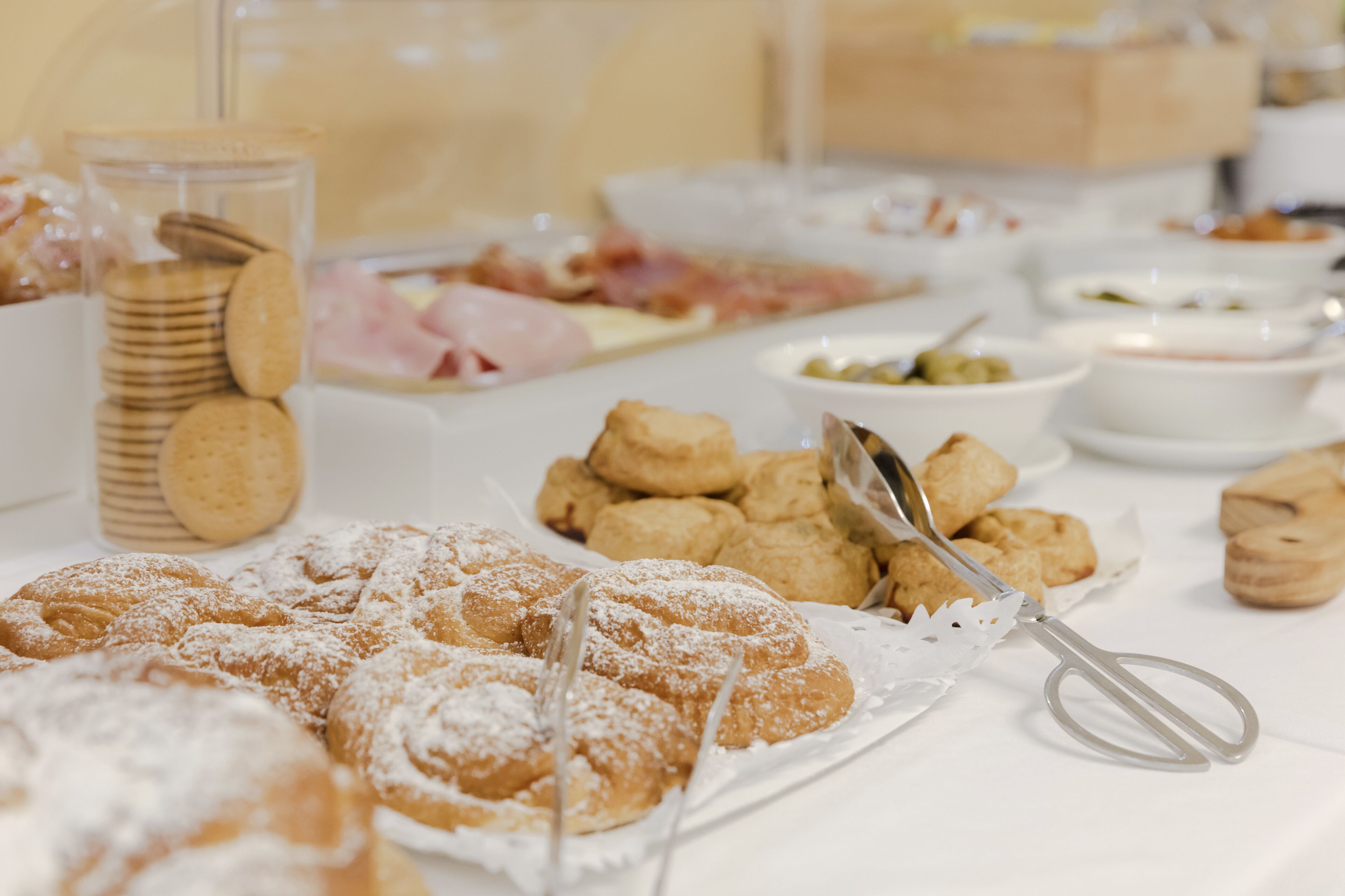 Una mesa de buffet con diversos pasteles y postres, incluyendo galletas y una variedad de salsas.