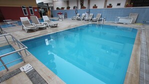 Une piscine intérieure dotée de chaises longues et d’un plongeoir.