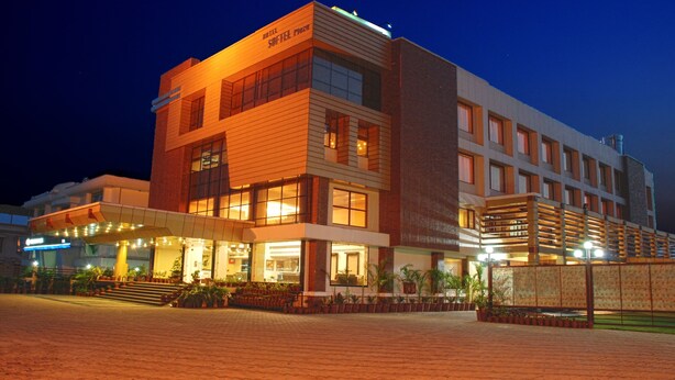 A hotel with a modern design, featuring a prominent entrance with steps and a covered area. - Hotel Softel Plaza (Dehradun)