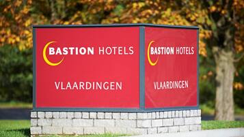 Placa vermelha para Bastion Hotels em Vlaardingen com um logotipo em forma de crescente.