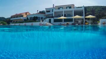 Una piscina al aire libre, sillones reclinables de piscina