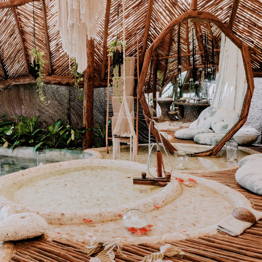 A spa area with a hot tub, seating, and plants.