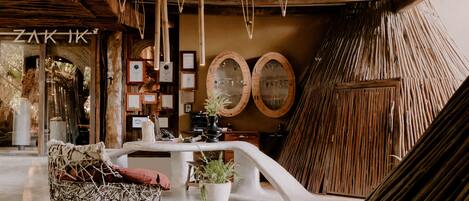 A cozy interior with a woven chair, a table with potted plants, and wooden decor.
