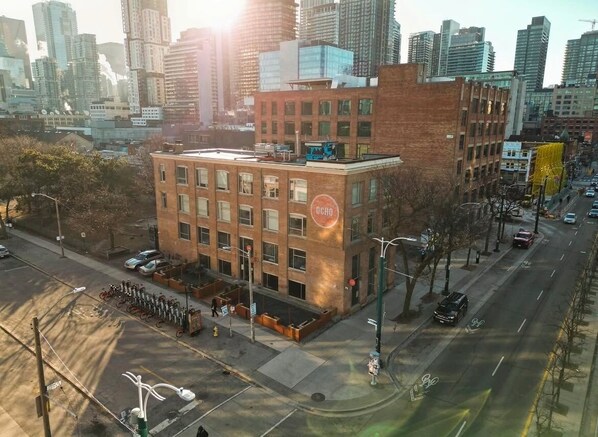 A multi-story building with a brick facade, a visible 'OCHO' sign, and a street view with cars and a bike lane.