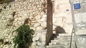Un bâtiment en pierre avec un escalier menant à l’entrée.