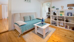 Un salon moderne avec un canapé, une table basse et une bibliothèque.