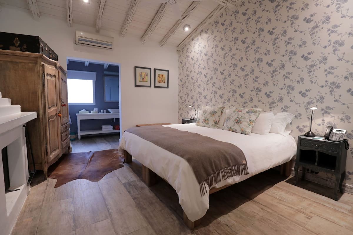 Ein Schlafzimmer mit Bett, Nachttisch, Kleiderschrank und einem angrenzenden Badezimmer.