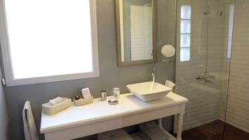 Une salle de bain avec un lavabo blanc, un miroir et une douche à parois de verre.