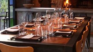 A long dining table set for a meal with wine glasses, plates, and cutlery. -  Finca Adalgisa Wine Hotel (Chacras de Coria)