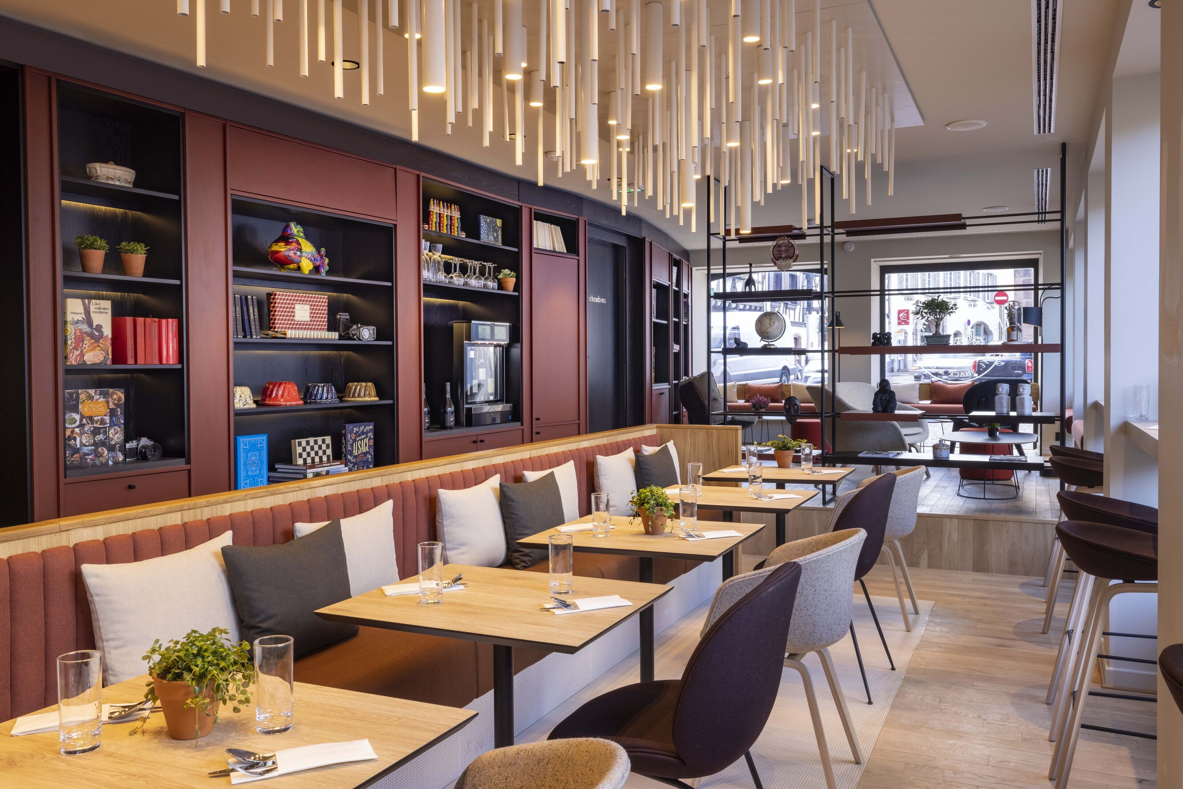 Un restaurante moderno con una barra larga, cabinas y estanterías.