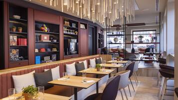 Un restaurante moderno con una barra larga, cabinas y estanterías.