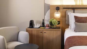 A hotel room with a bed, a small wooden nightstand, a table, and two chairs.
