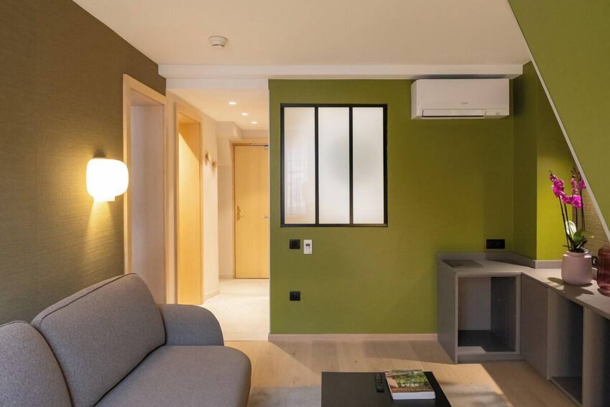 Ein modernes Wohnzimmer mit einer Couch, einem Couchtisch und einer Wandklimaanlage.