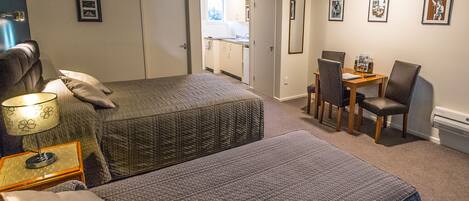 A bedroom with two beds, a desk, and a chair.