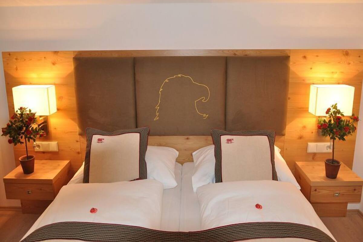 A double bed with a headboard, two bedside tables, and two lamps.