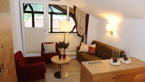 Una habitación acogedora con una silla roja, un sofá marrón, un armario de madera y una mesa con plantas en macetas.