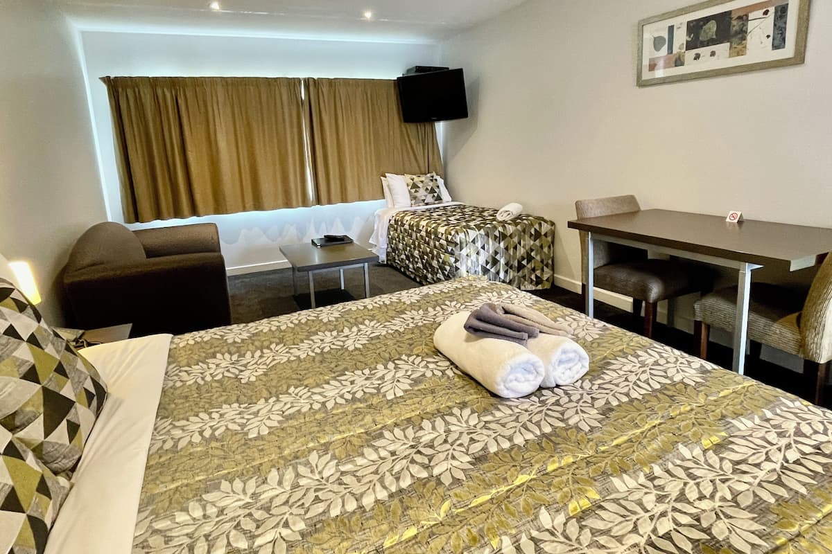Une chambre d’hôtel avec un grand lit, un bureau, une chaise et un canapé.