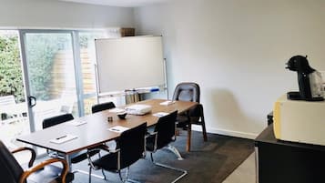 A conference room with a large table, chairs, a whiteboard, and a projector.