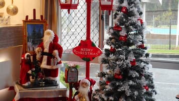 A decorated room with a Christmas tree, a Santa Claus figure, and a sign that reads "Merry Christmas".