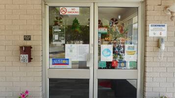 A hotel entrance with a 'WELCOME' sign, a 'NO SMOKING' sign, a key box, and a 'Molly Morgan' sign.