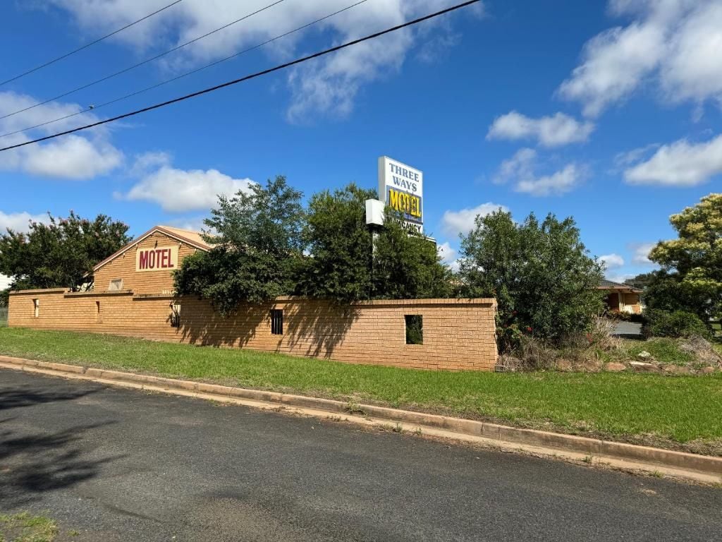 A motel with a sign indicating it has three ways.