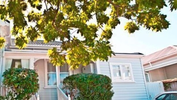 A row of white houses with bay windows and a central building with a gabled roof. - Eden Park Motel (Auckland)