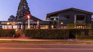 A building with a sign for 'Jolly Good Fellow's Restaurant & Bar' and a 'Conference Centre' sign. - Twin Peaks Lakeside Inn (Taupo)
