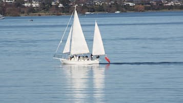 Un voilier avec plusieurs voiles sur un lac calme.