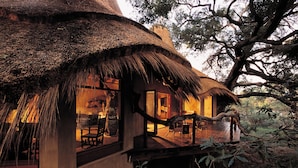 A thatched-roof house with a wooden deck and large windows. - Pondoro Game Lodge  - Open to Kruger Park (Hoedspruit)