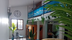 Amplio espacio interior con piscina, asientos de madera y diversas plantas.
