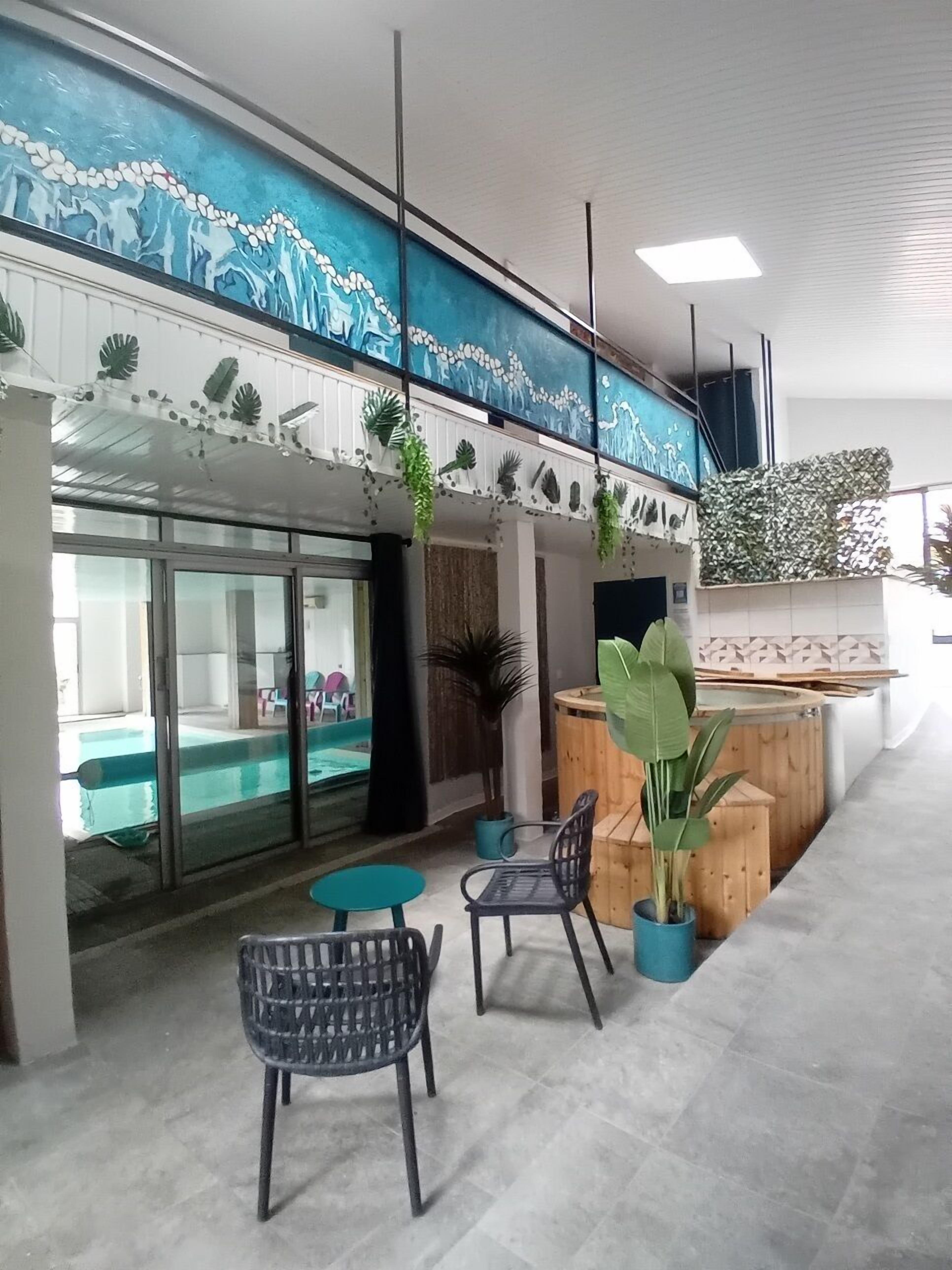 A modern lobby with a reception desk, seating area, and a view of a pool.