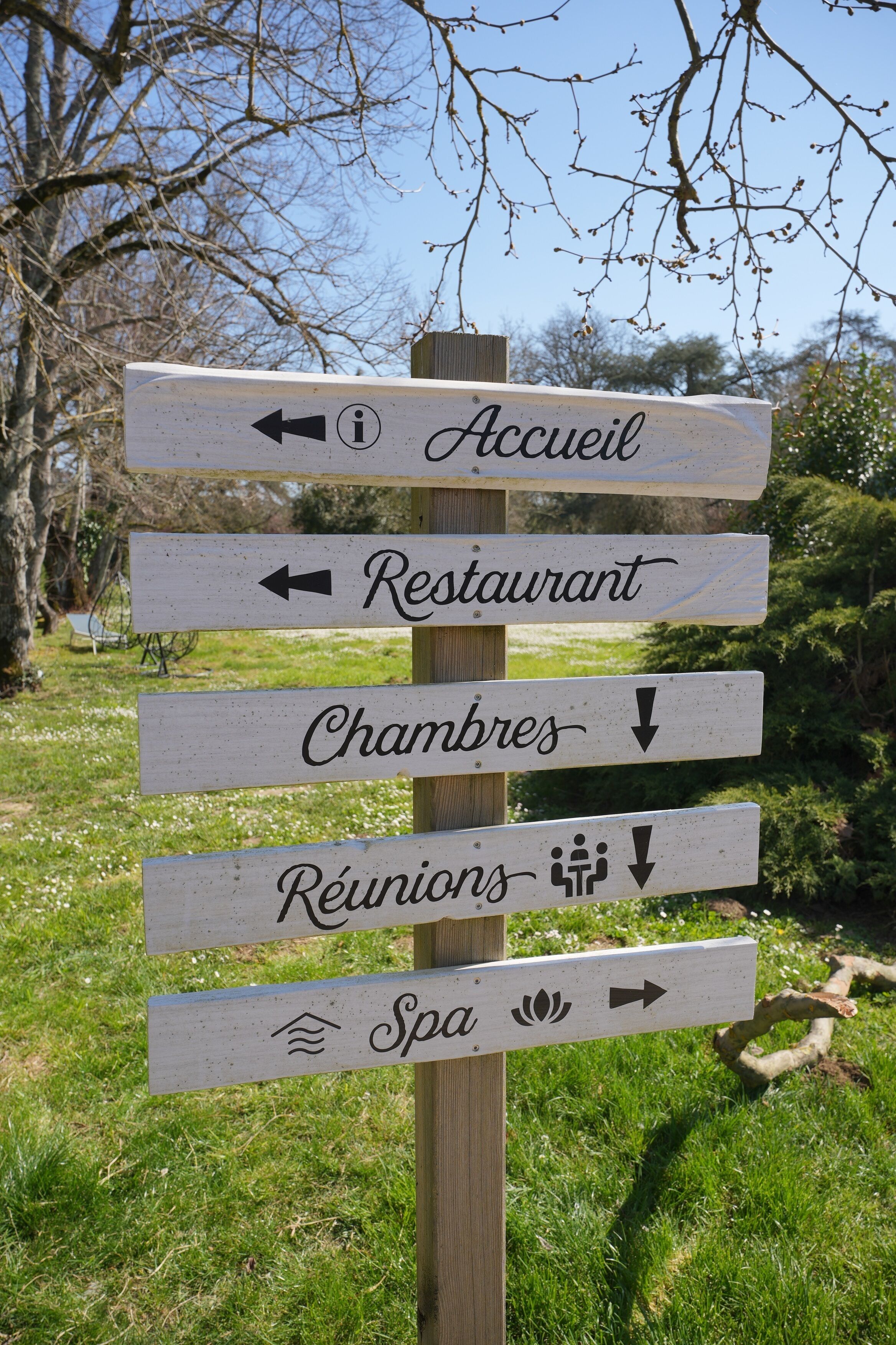 A directional signpost with arrows pointing to various amenities including a restaurant, spa, and rooms.