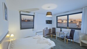 Una habitación de hotel con cama, escritorio, silla y televisión.