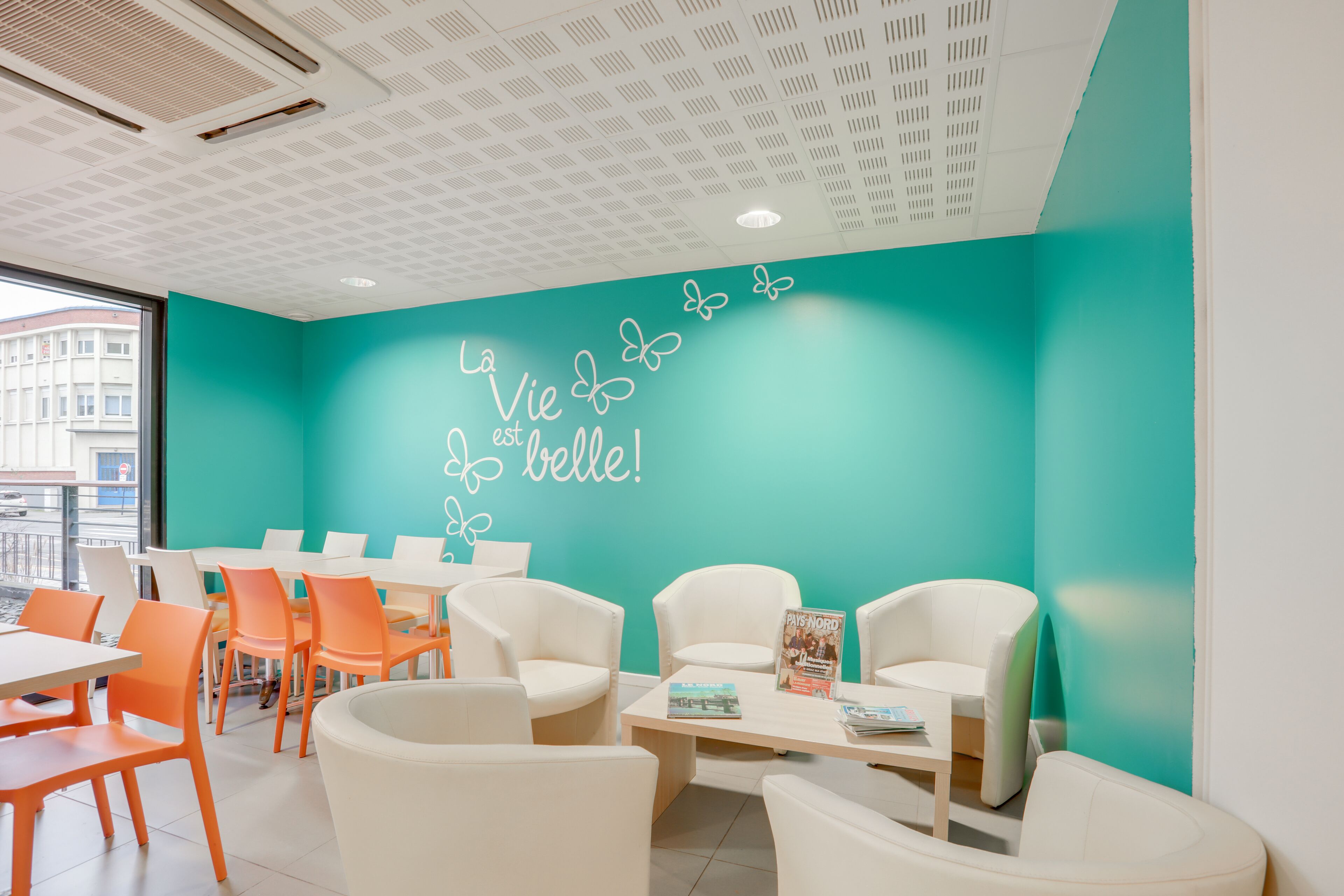 A modern interior with teal walls, white furniture, and a ceiling with a grid pattern.