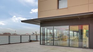 Un edificio moderno con amplios ventanales y una terraza de madera.