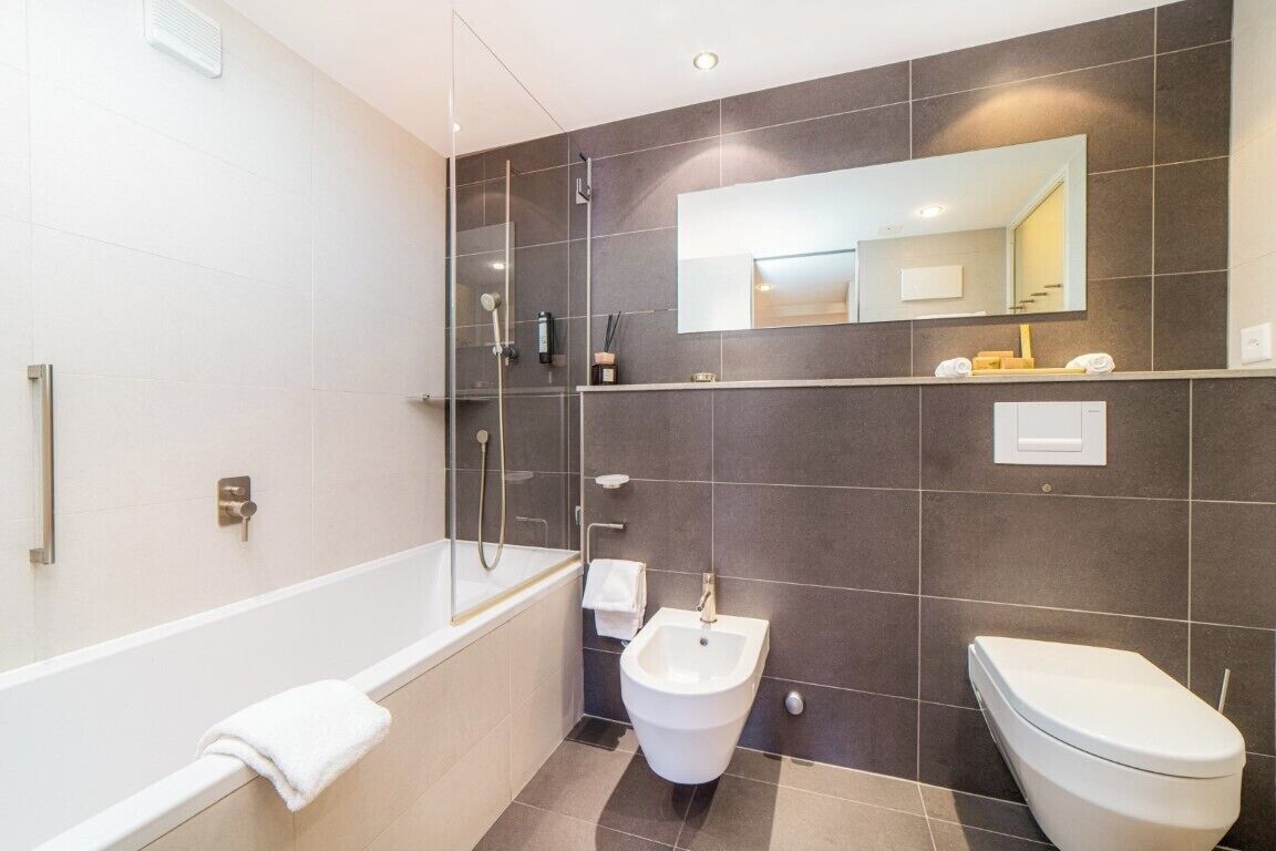A modern bathroom with a bathtub, a bidet, and a toilet.