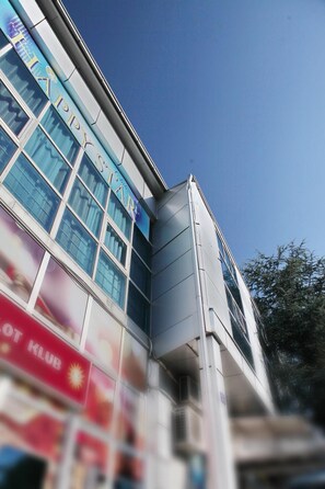 A building with multiple floors, large windows, and a clear sky.