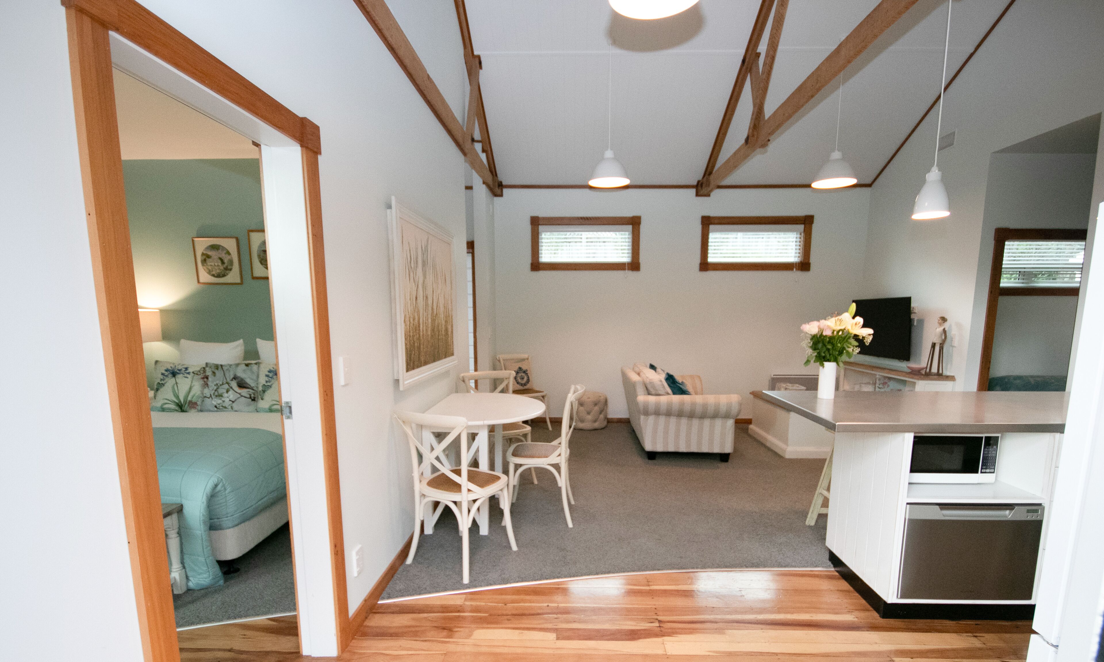 A compact living space with a kitchenette, a dining area, and a bedroom.