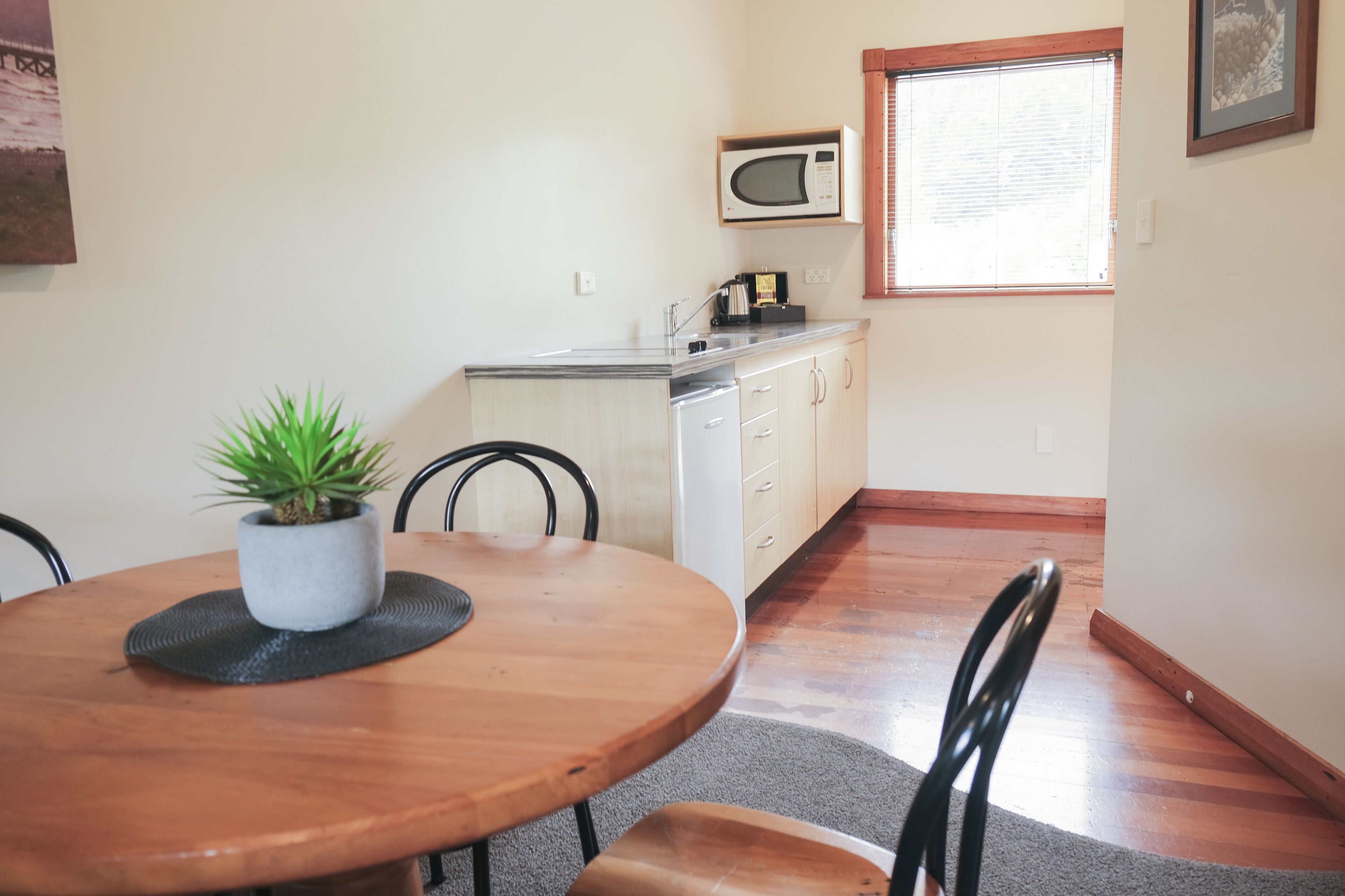 A compact kitchen with a microwave, a sink, and a window.