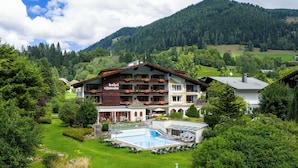 Un hotel con piscina, rodeado de exuberante vegetación y montañas.