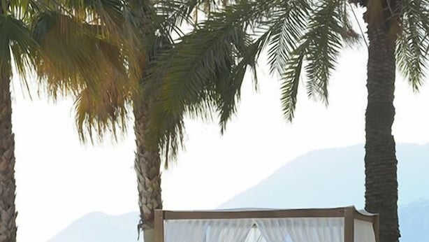 A poolside area with a canopy and a bench labeled "BEACH".