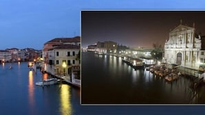 Un canal bordé d’immeubles et traversé par un pont, de nuit.