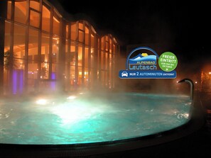 A hot tub with a sign indicating a free entry offer. - Activ Pension Bergfrieden (Leutasch)