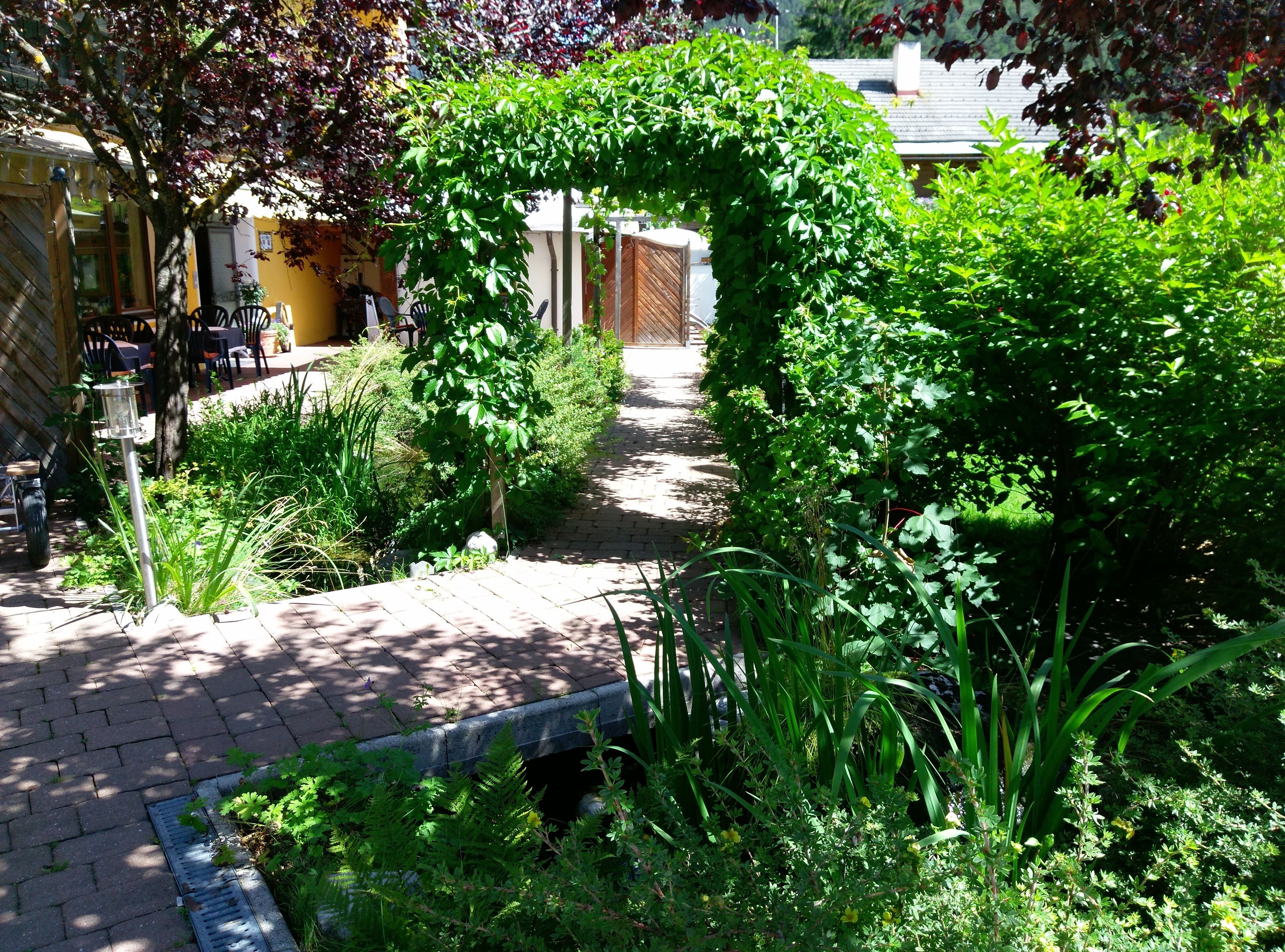 A garden pathway with a wooden fence and a brick walkway.