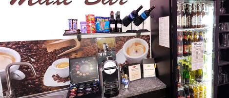A bar area with a coffee machine, espresso options, and a selection of alcoholic beverages.