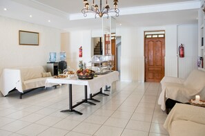 Un comedor con una mesa de buffet, un sofá y una silla.