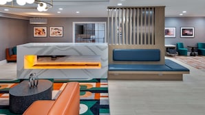 A modern lobby with a reception desk, seating area, and artwork on the walls. - Homewood Suites by Hilton Boston/Canton, MA (Canton)