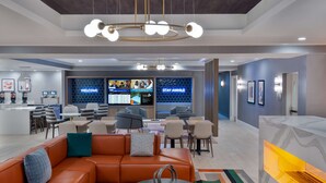 A modern lobby with a reception desk, seating area, and a large digital display. - Homewood Suites by Hilton Boston/Canton, MA (Canton)