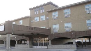 A multi-story hotel with a prominent 'HOTEL' sign above the entrance. - Super 8 by Wyndham Saskatoon Near Downtown (Saskatoon)