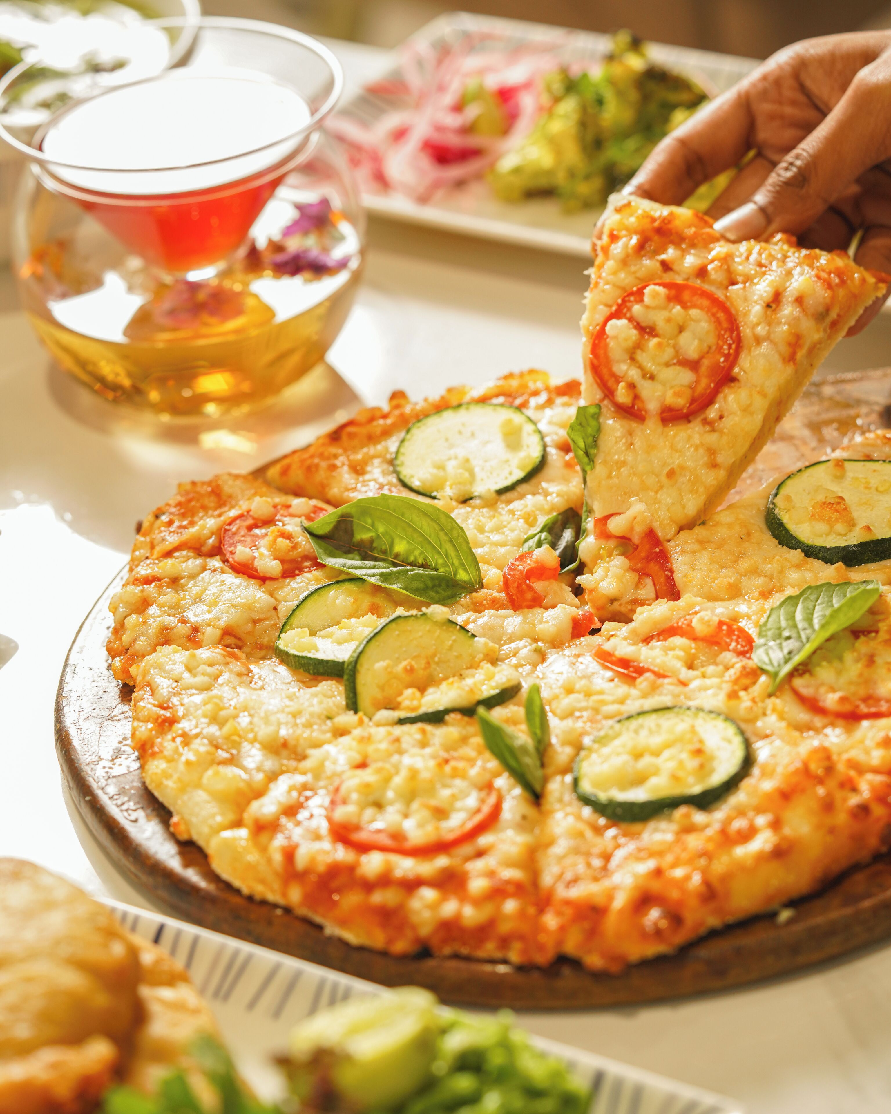 A pizza with various toppings on a wooden board.